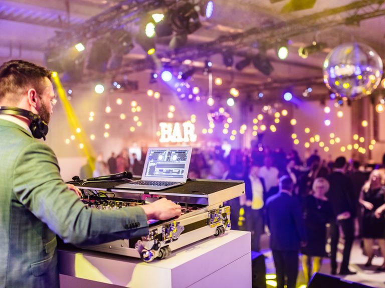 DJ Mischpult Firmenfeier Lichter BAR Leuchtbuchstaben tanzende Menschen Bühne Spotlight