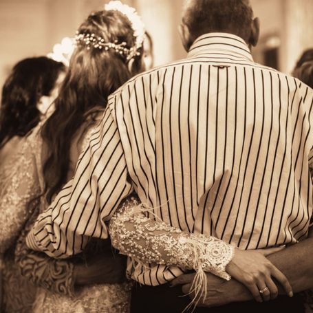 Familie Braut Vater Mutter umarmen sich auf Hochzeit der Tochter und tanzen gemeinsam