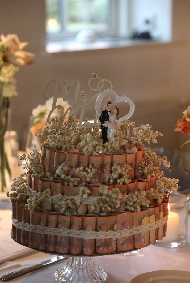 Geldgeschenk zur Hochzeit in Form einer Torte aus Geldscheinen mit Blumen dekoriert